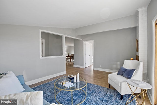 living room featuring lofted ceiling, baseboards, and wood finished floors