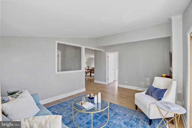 living room with vaulted ceiling, wood finished floors, and baseboards