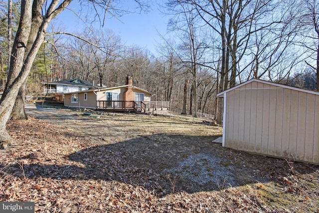 view of yard with an outbuilding, a deck, and a storage unit