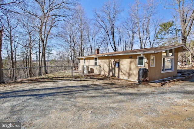 view of front of house with a chimney and fence