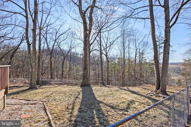 view of yard featuring fence and a wooded view