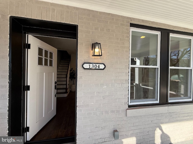 view of exterior entry featuring brick siding