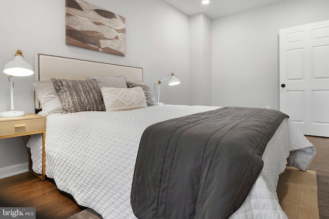 bedroom with baseboards, wood finished floors, and recessed lighting