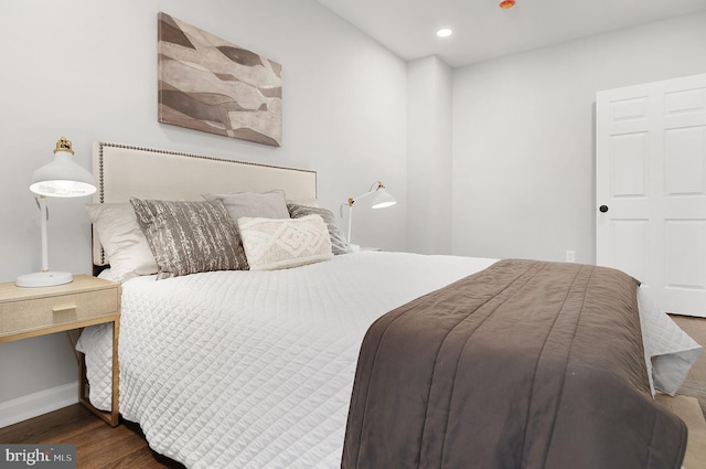 bedroom featuring baseboards, wood finished floors, and recessed lighting