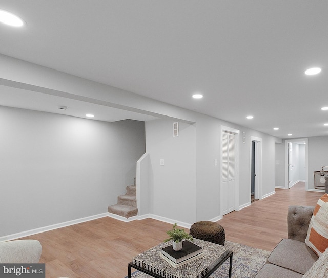 living room featuring recessed lighting, visible vents, stairway, light wood-type flooring, and baseboards