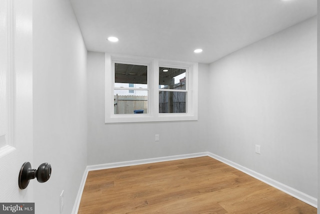 empty room with recessed lighting, light wood-style flooring, and baseboards