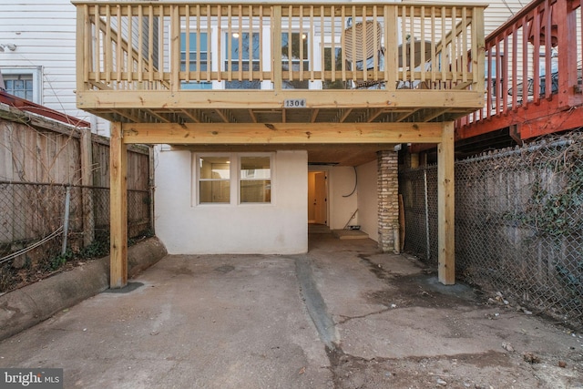 exterior space featuring a carport, fence, and stucco siding