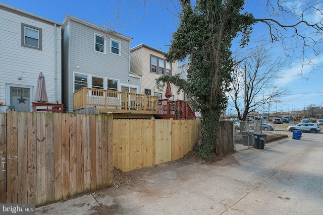 rear view of house featuring fence and a wooden deck