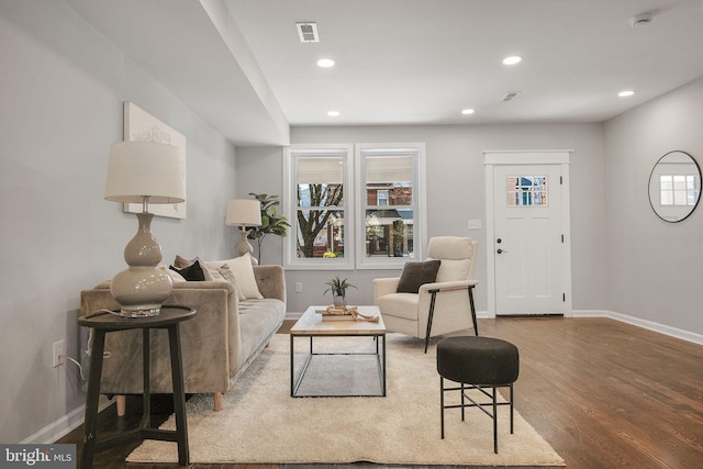 living area with recessed lighting, wood finished floors, visible vents, and baseboards