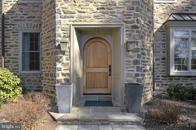 doorway to property featuring stone siding