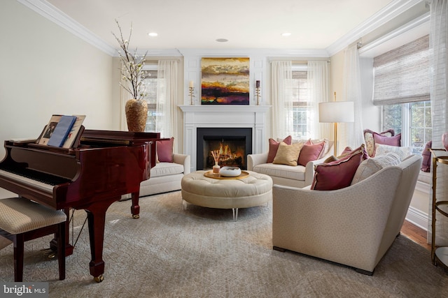 sitting room with recessed lighting, a warm lit fireplace, and crown molding