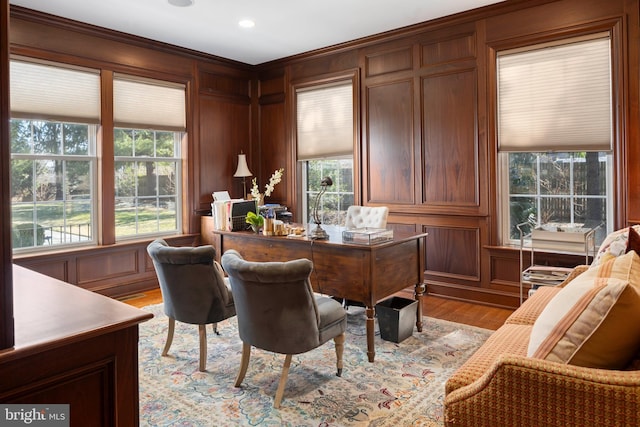 office area with wooden walls, recessed lighting, a healthy amount of sunlight, and light wood-style floors