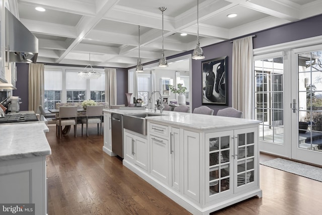 kitchen with a sink, dark wood-type flooring, glass insert cabinets, white cabinetry, and stainless steel dishwasher