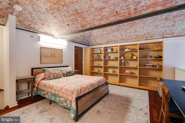 bedroom with brick ceiling and dark wood-type flooring