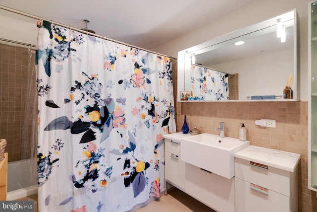 full bath featuring shower / tub combo, vanity, and tile walls