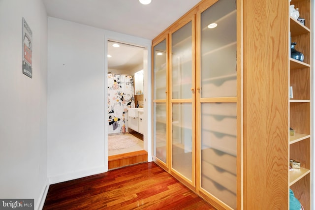 hallway with recessed lighting, dark wood-style flooring, and baseboards