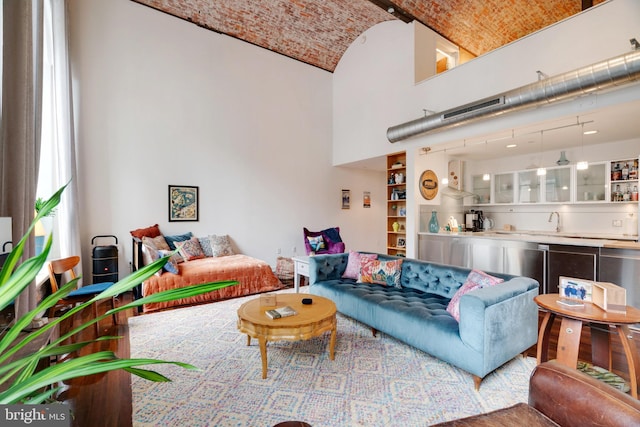 living room featuring brick ceiling and a towering ceiling