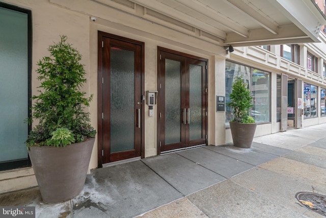 view of exterior entry featuring french doors, elevator, and stucco siding