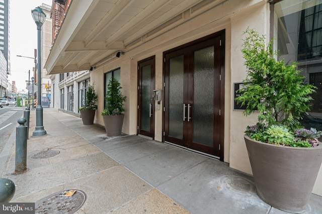 view of exterior entry with french doors and stucco siding