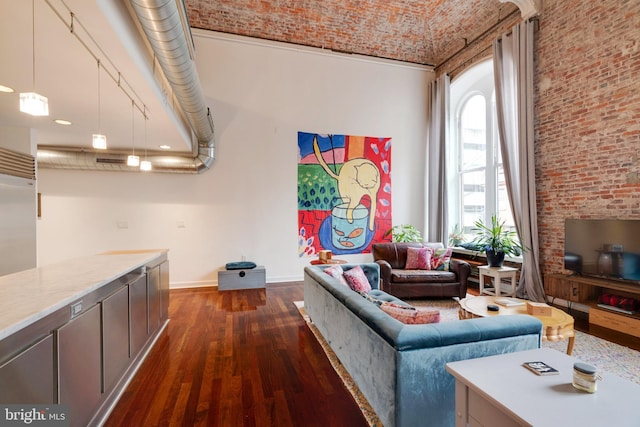 living area with brick ceiling, brick wall, dark wood finished floors, and baseboards