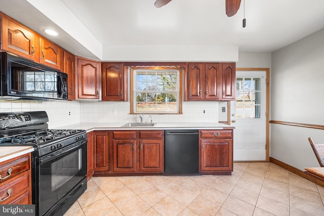 kitchen featuring black appliances, backsplash, light countertops, and a sink