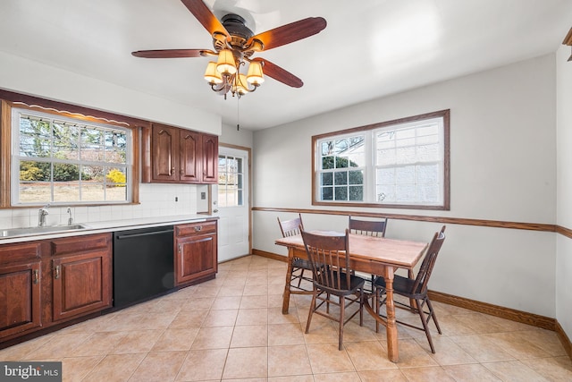 kitchen featuring light countertops, decorative backsplash, a sink, dishwasher, and baseboards