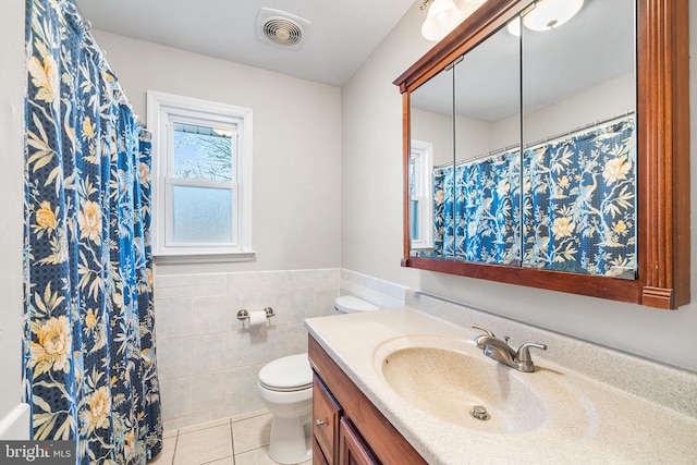 full bath with visible vents, toilet, tile patterned floors, vanity, and tile walls