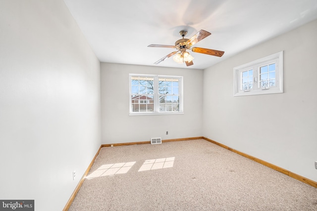 empty room featuring a healthy amount of sunlight, baseboards, and visible vents