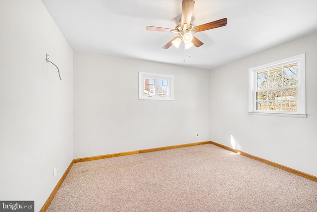 spare room featuring a ceiling fan, carpet, and baseboards