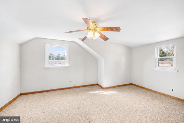 bonus room featuring carpet, a healthy amount of sunlight, vaulted ceiling, and baseboards