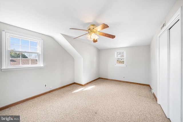 additional living space featuring baseboards, a ceiling fan, a wealth of natural light, and carpet flooring