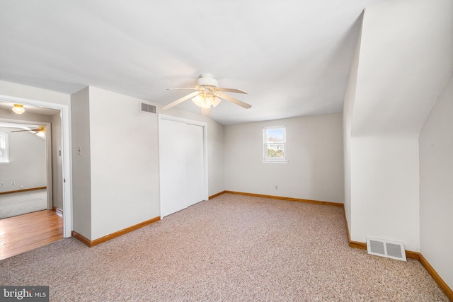 interior space featuring ceiling fan, carpet, and visible vents