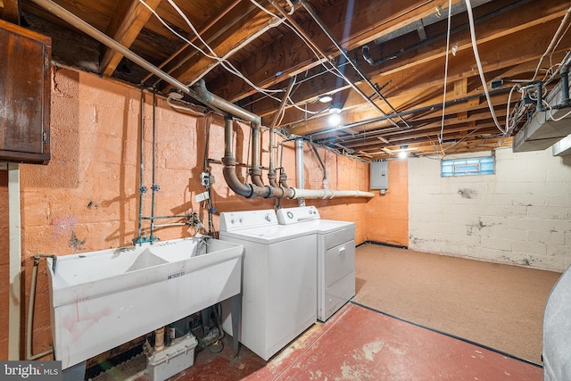 laundry room featuring laundry area, washing machine and dryer, electric panel, and a sink