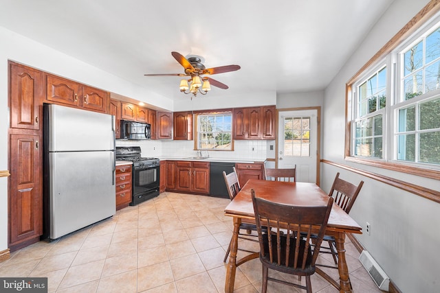 kitchen with light tile patterned floors, tasteful backsplash, visible vents, light countertops, and black appliances