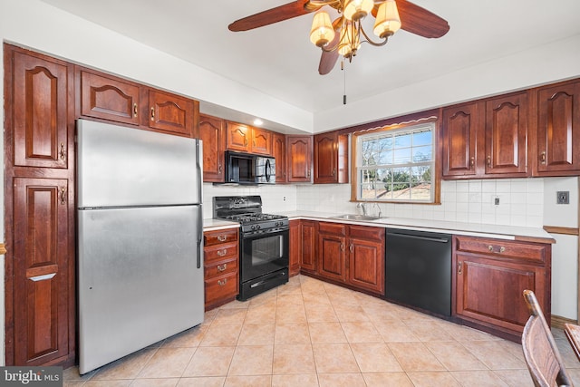 kitchen featuring black appliances, backsplash, light countertops, and a sink