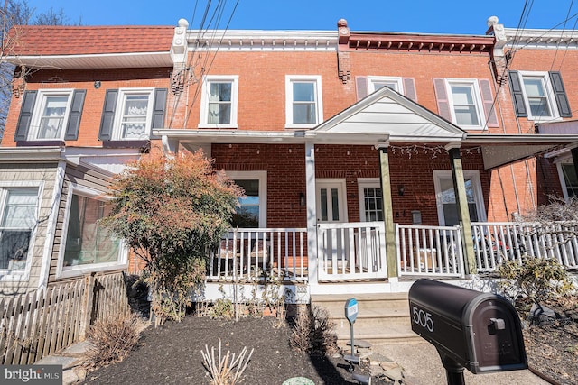 townhome / multi-family property with covered porch and brick siding