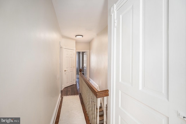 hall with baseboards and dark wood finished floors