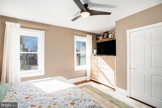 unfurnished bedroom with a ceiling fan, baseboards, and wood finished floors