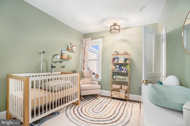 bedroom with a crib and baseboards