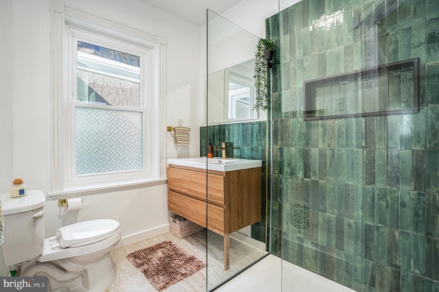 bathroom featuring a walk in shower, vanity, toilet, and tile patterned floors