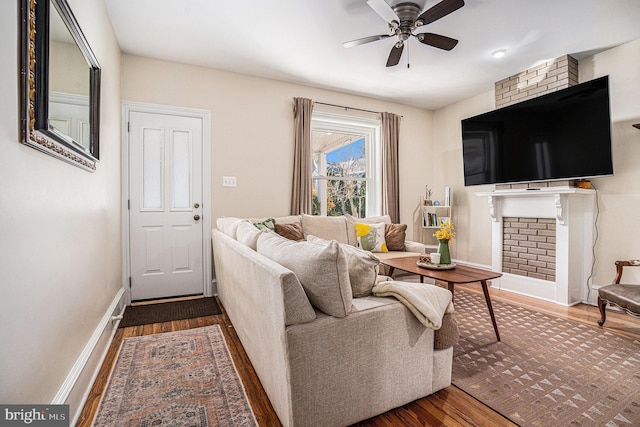 living area with ceiling fan, baseboards, and wood finished floors