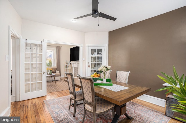 dining area with baseboards, ceiling fan, and light wood-style floors