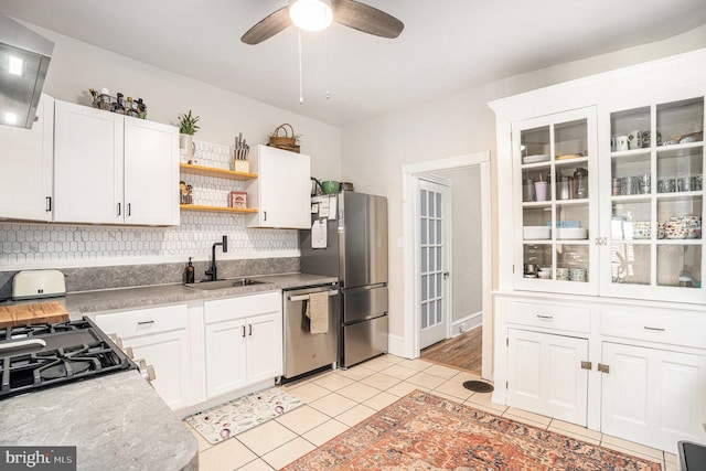 kitchen with decorative backsplash, appliances with stainless steel finishes, open shelves, a sink, and light tile patterned flooring