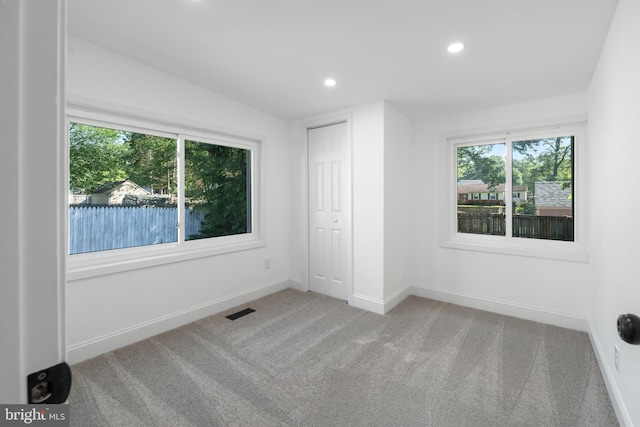 unfurnished bedroom with recessed lighting, visible vents, light carpet, and baseboards