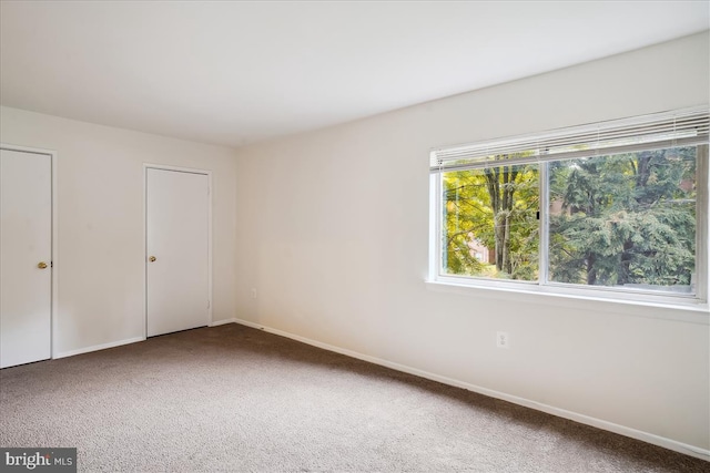 unfurnished bedroom with carpet flooring and baseboards