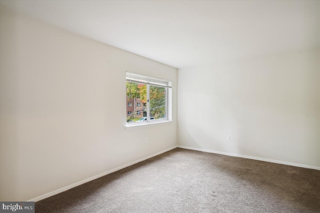 carpeted empty room featuring baseboards