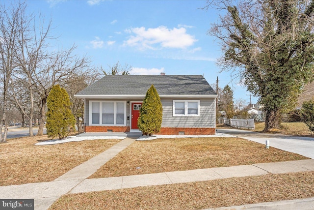 bungalow featuring crawl space, driveway, a front lawn, and a shingled roof