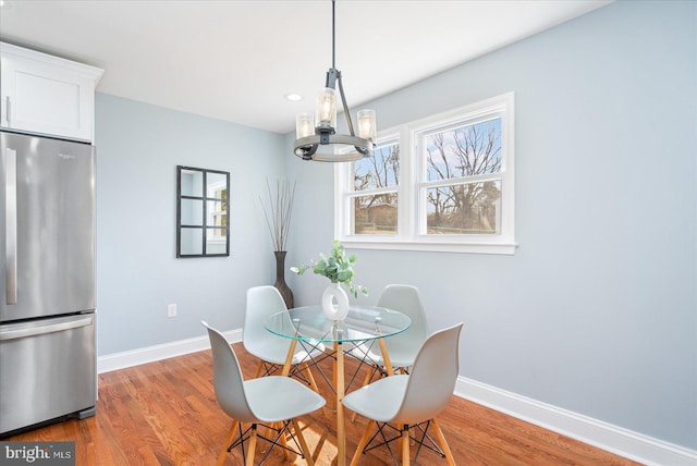 dining space with recessed lighting, an inviting chandelier, wood finished floors, and baseboards