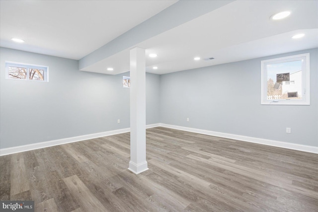 below grade area featuring recessed lighting, wood finished floors, visible vents, and baseboards