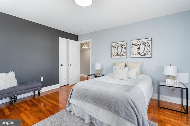 bedroom featuring a closet, baseboards, and wood finished floors